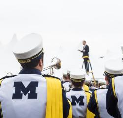 The Michigan Marching Band playing with its conductor